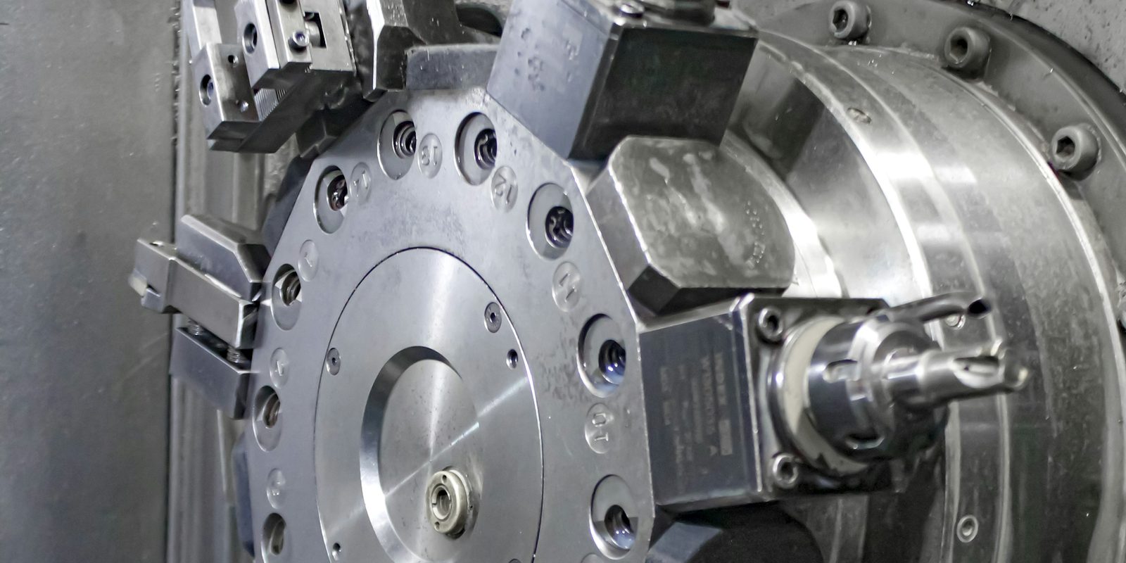 The tool turret of a CNC lathe with live tooling mounted, seen inside the machine