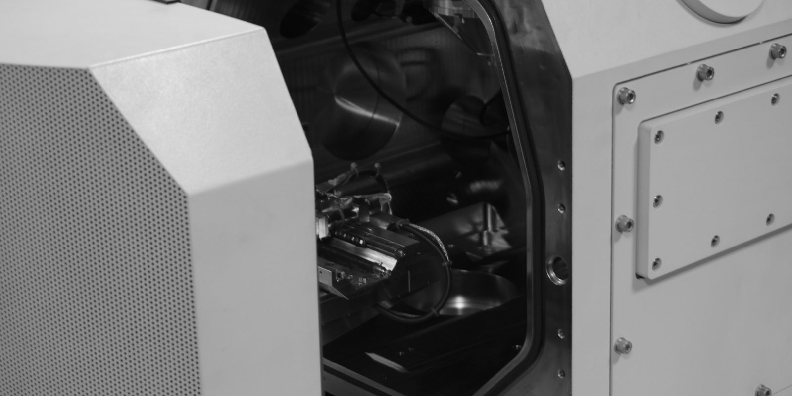 A white CNC machining centre with the enclosure open, showing the spindle and the tool holders inside