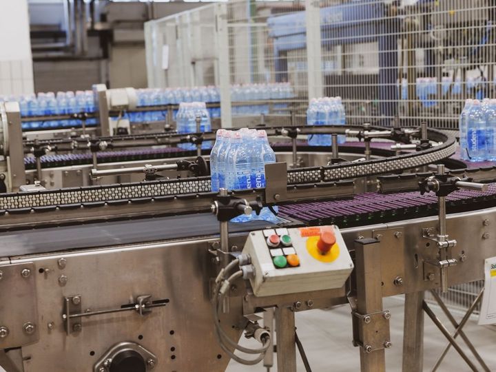 Shrink-wrapped packs of bottled water on a conveyor in a bottling plant