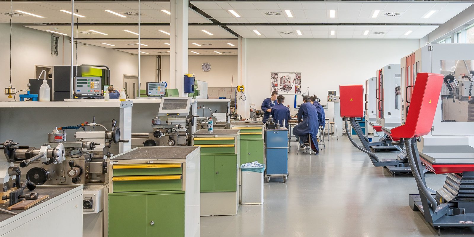 A bright, tidy machining workshop with lathes, tool cabinets and enclosed machines